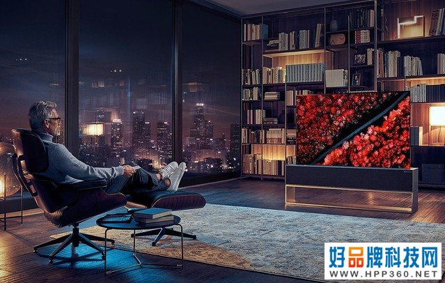 Egy férfi keresztbe tett lábakkal egy támlás széken ül, egy LG SIGNATURE felcsavarható OLED TV felé fordulva.